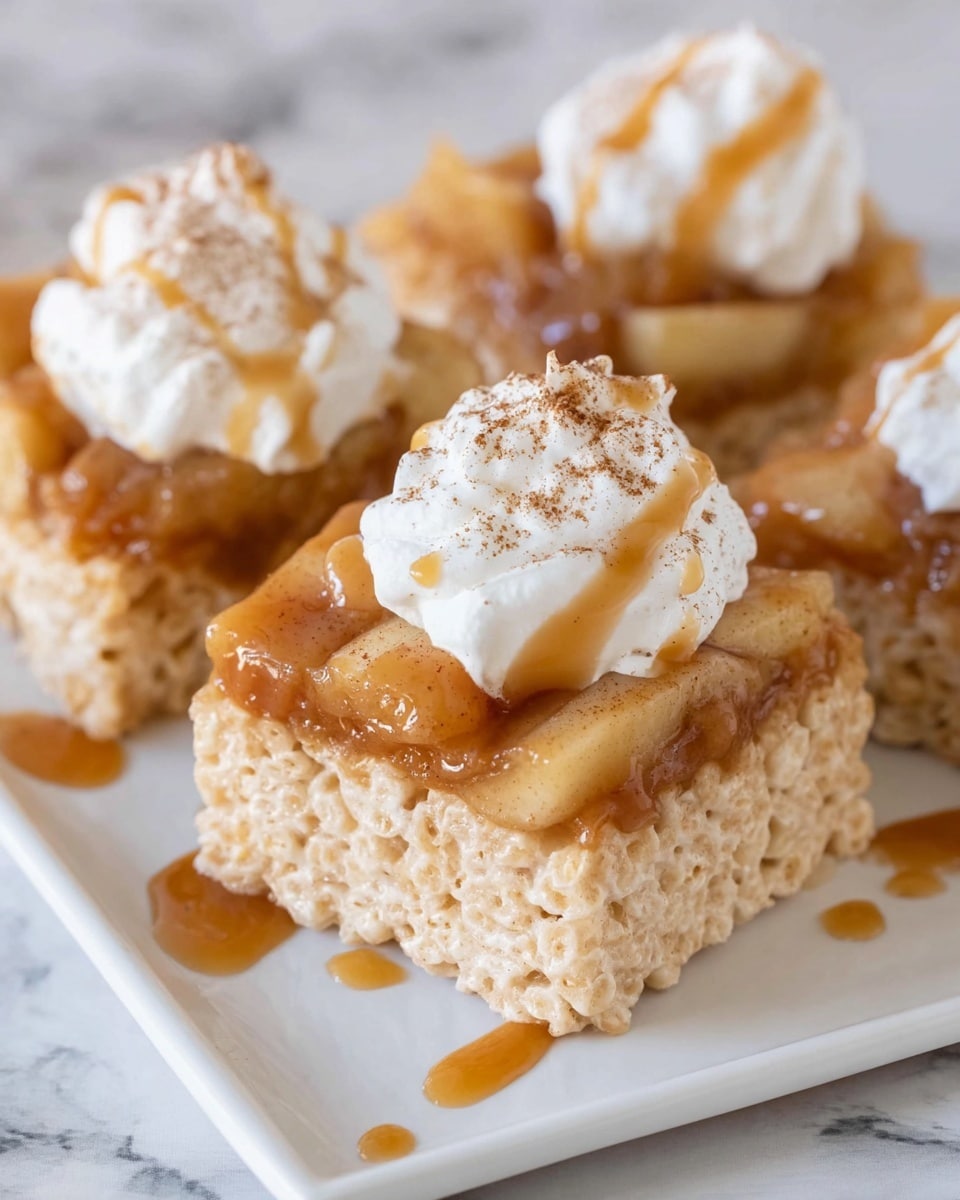 The image shows three square rice crispy treats on a white plate with a white marbled surface underneath. Each treat has three layers: a bottom light golden crispy layer with a rough texture, a middle layer of glossy caramel-colored cooked apples with a soft, chunky texture, and a top layer of white whipped cream that looks soft and fluffy, sprinkled with cinnamon powder. There is a drizzle of caramel sauce over the apple layer and around the treats on the plate. Photo taken with an iphone --ar 4:5 --v 7