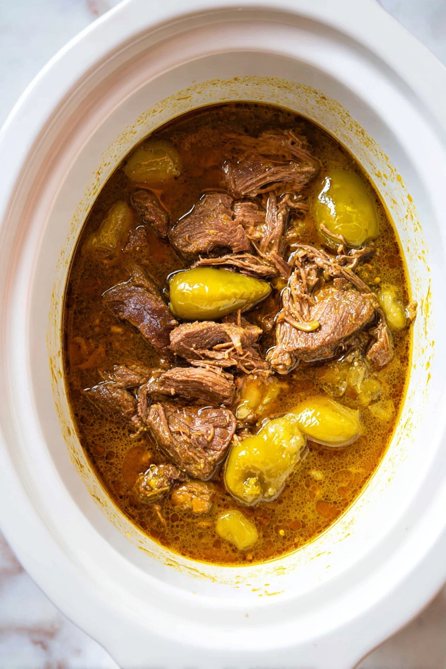 Slow Cooker Mississippi Roast, Mississippi Roast recipe, easy slow cooker dinner, tender beef roast, flavorful beef recipe - A single piece of raw beef with rich red and some white fat parts sits in the center of a white slow cooker. The beef is surrounded by a shallow pool of light brown liquid. The white slow cooker contrasts with the soft white marbled texture surface beneath. photo taken with an iphone --ar 2:3 --v 7